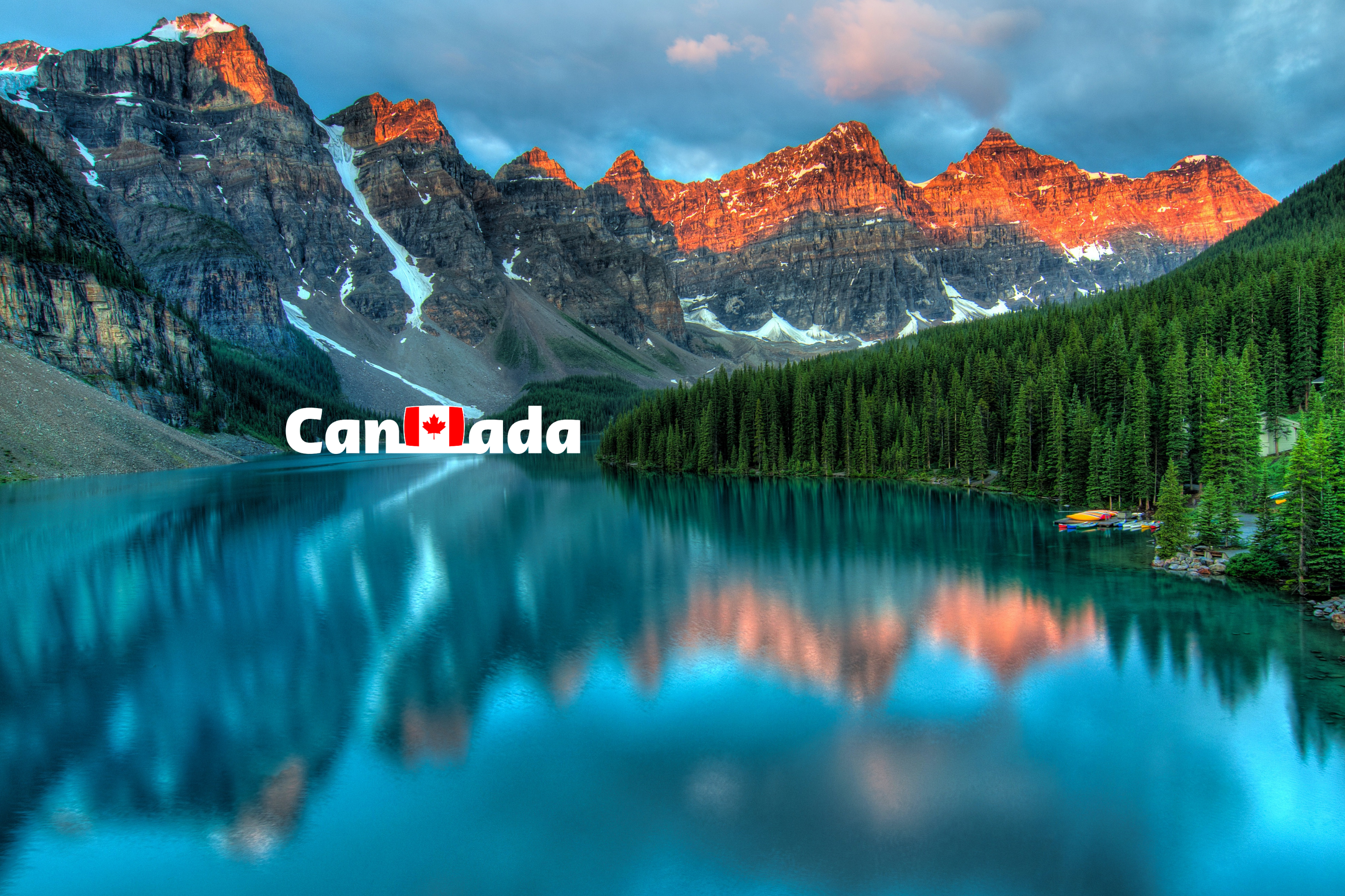 Scenic view of a lake with mountains and trees, featuring the word 'Canada'.